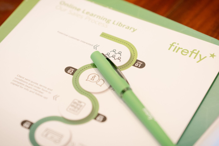 A green Firefly pen on top of the Online Learning Library brochure
